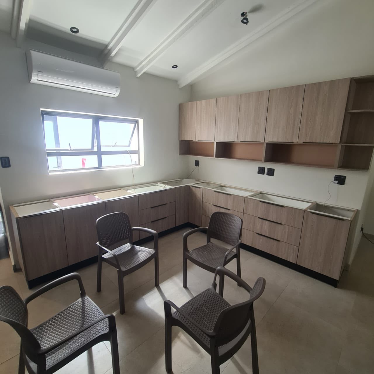 Wood grain kitchen cupboards being installed, base units and wall units fitted before the countertops go on