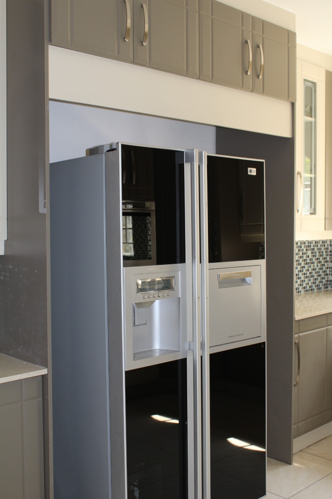 Grey shaker kitchen with built-in fridge and mosaic splashback