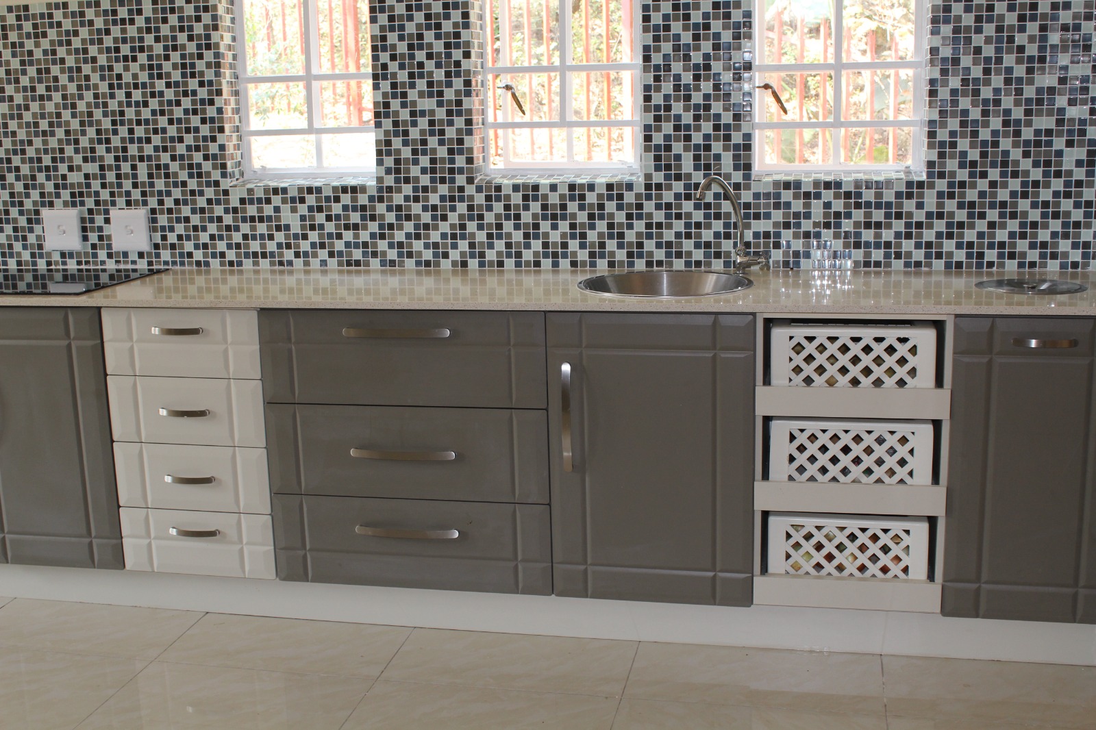 High-gloss kitchen with mosaic splashback and induction hob