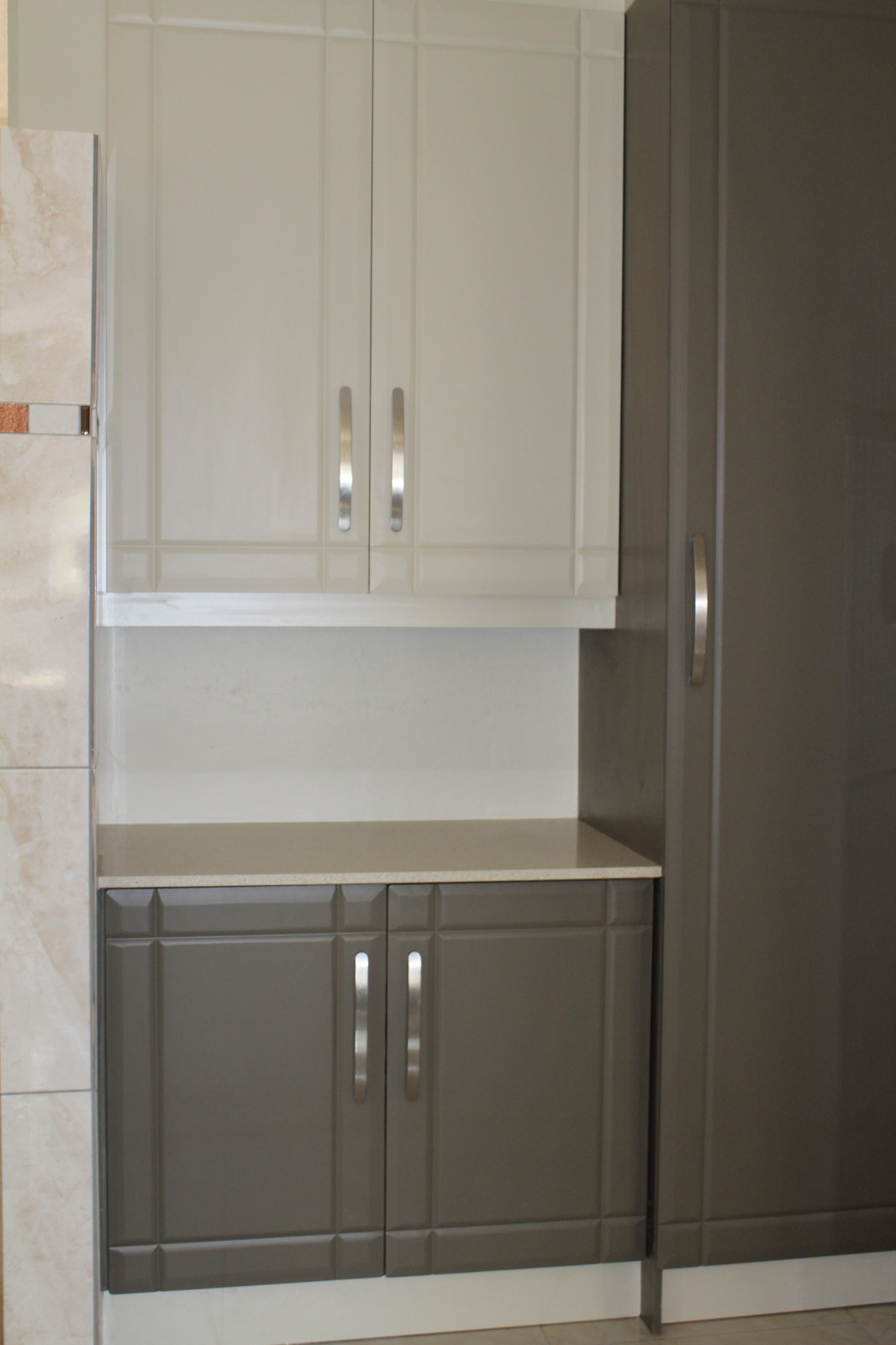 Two-tone grey and cream high-gloss cabinets